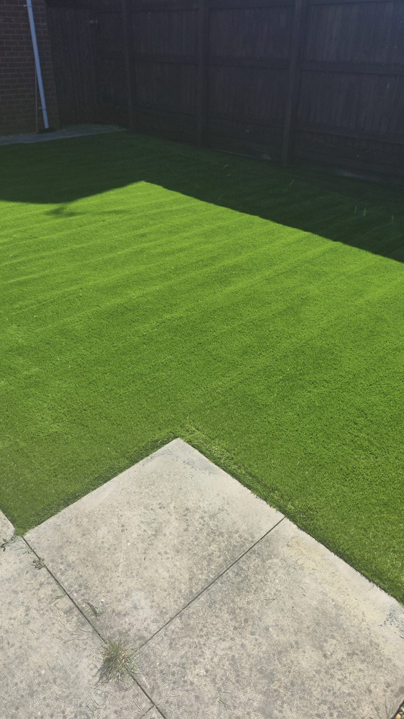 Artificial grass lawn meeting a paving slab edge cleanly
