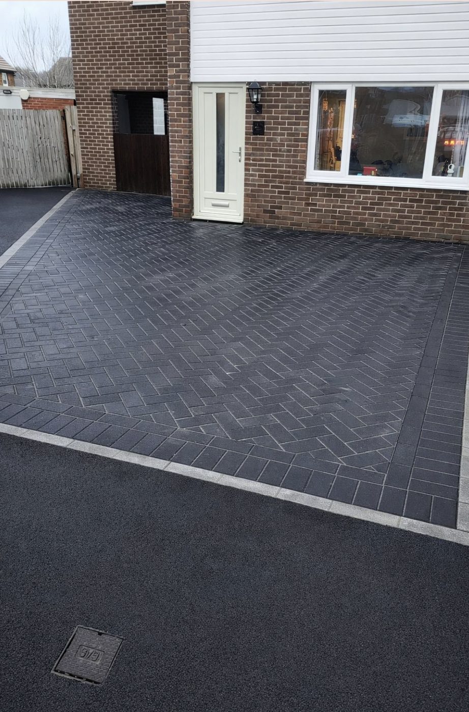 Charcoal block paving driveway laid in herringbone with a soldier course border