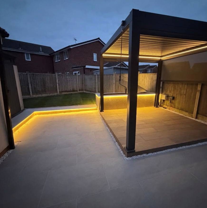 Louvred pergola with warm lighting over a porcelain patio built by GreenForge