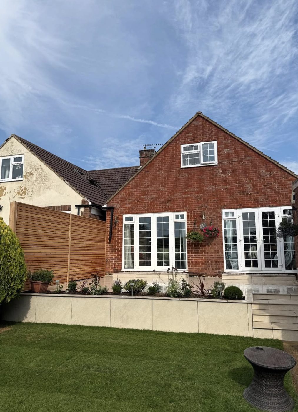 Slatted timber screen above a raised planted border beside a patio